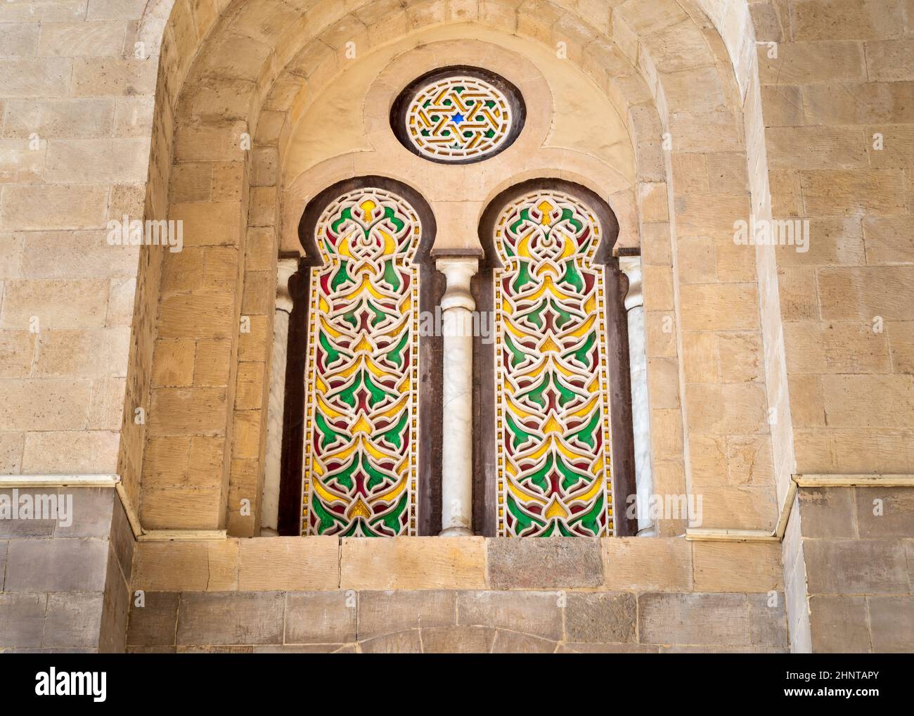 Due finestre ad arco con stucco perforato adiacenti esterne con coloratissimi motivi di vetro colorato, presso il complesso Qalawun, il Cairo Foto Stock