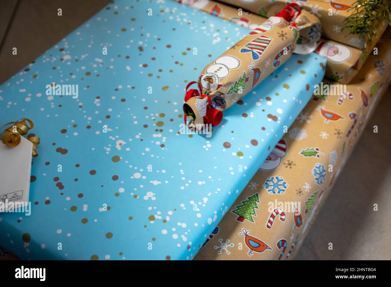 Regali natalizi avvolti e regali natalizi sotto l'albero di Natale mostra decorativi unboxing evento con tradizionale celebrazione della stagione invernale fatta a mano per i bambini scintillanti bellezza occhi Foto Stock