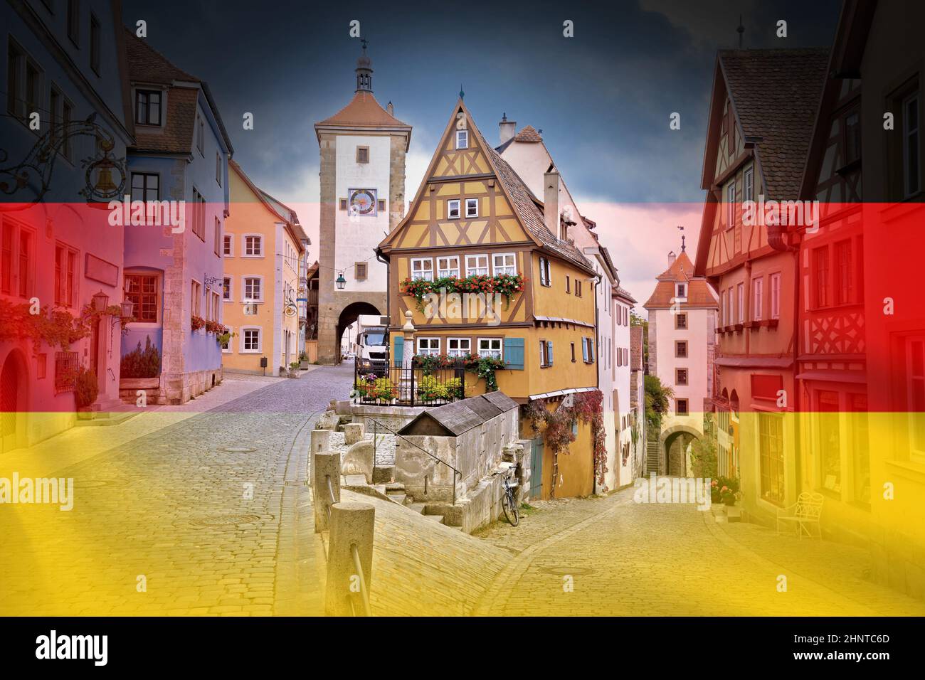 Strada acciottolata e architettura della storica città di Rothenburg ob der Tauber sulla bandiera tedesca sovraimpressione Foto Stock