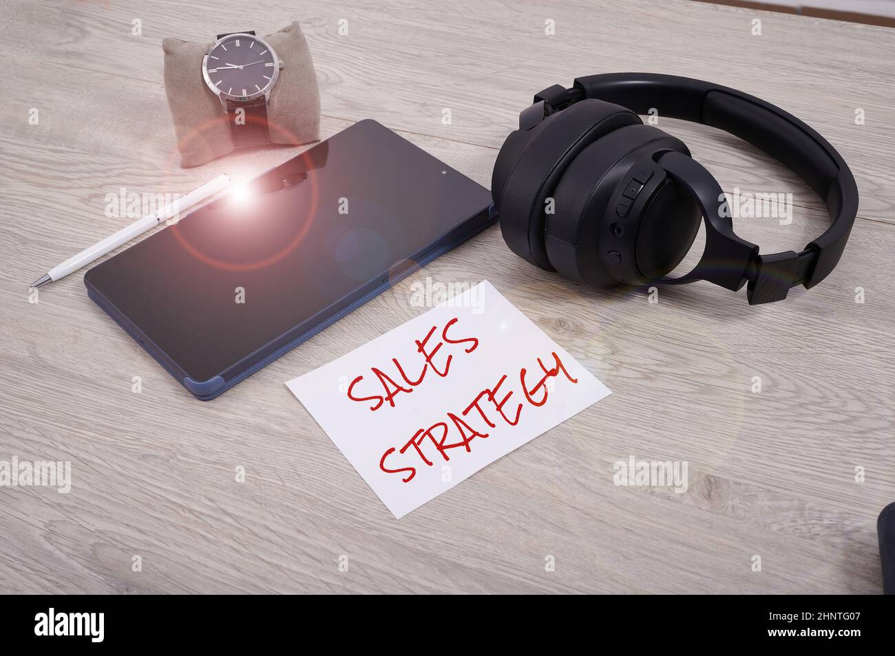 Testo scritto a mano strategia di vendita. Piano fotografico concettuale per raggiungere e vendere al vostro mercato di destinazione Marketing pagina di notebook in bianco con una calcolatrice e geometrico cancelleria su tavola. Foto Stock