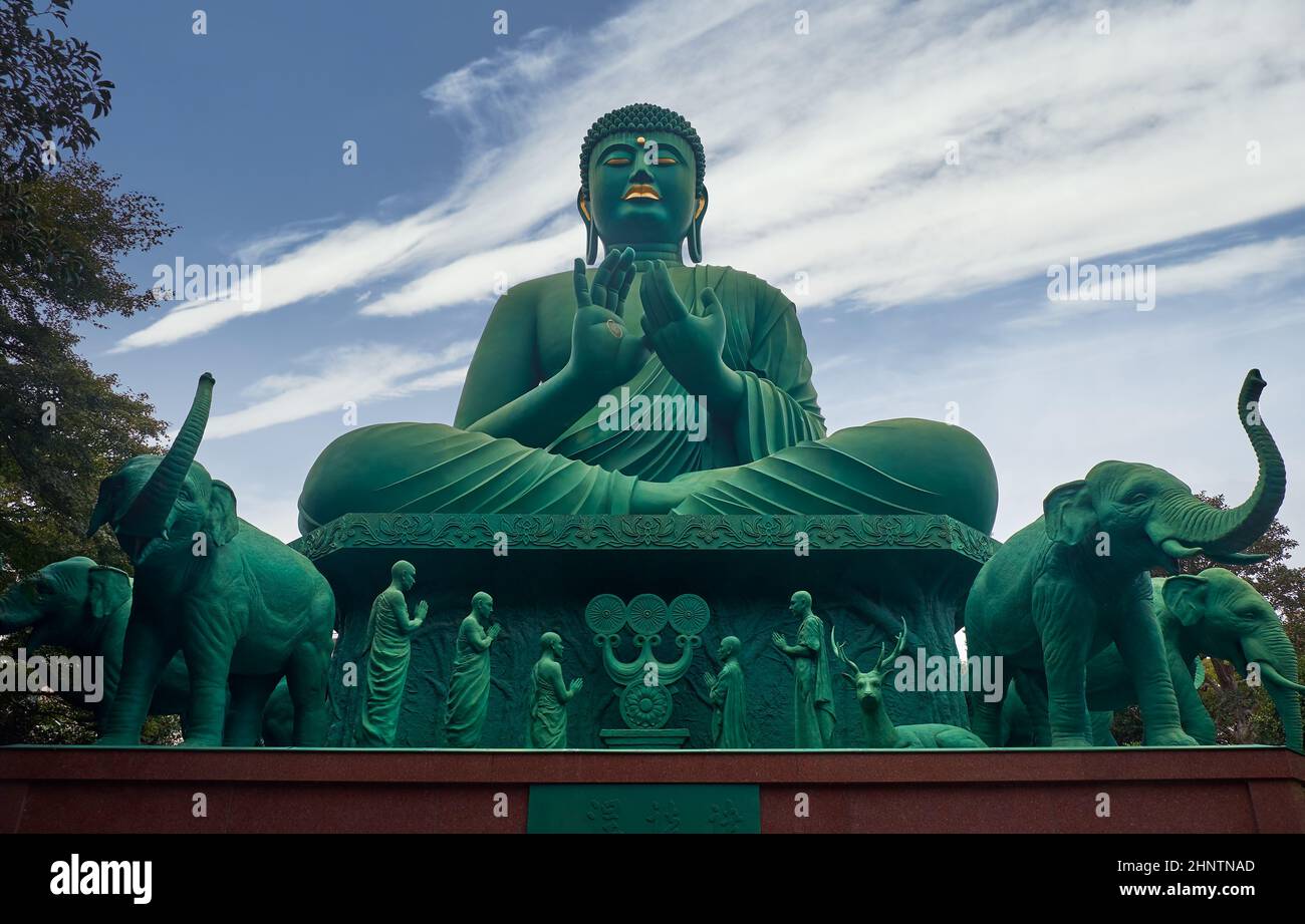 Il Buddha gigante di bronzo circondato da statue di elefanti, renne e monaci per essere una rappresentazione del primo sermone dato dal Buddha di Gautama. Tog Foto Stock