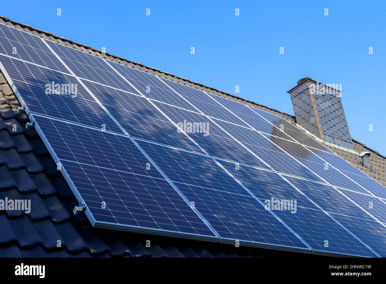 Pannelli solari che producono energia pulita su un tetto di una casa residenziale Foto Stock