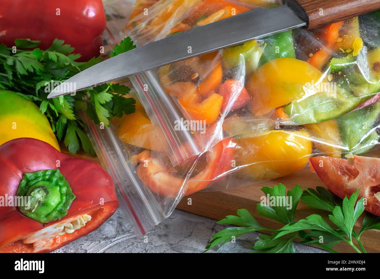 Affettato frutti maturi di peperone in sacchetti di cellophane, preparati per il congelamento e la conservazione a lungo termine nel comparto freezer del frigorifero. V. Anteriore Foto Stock