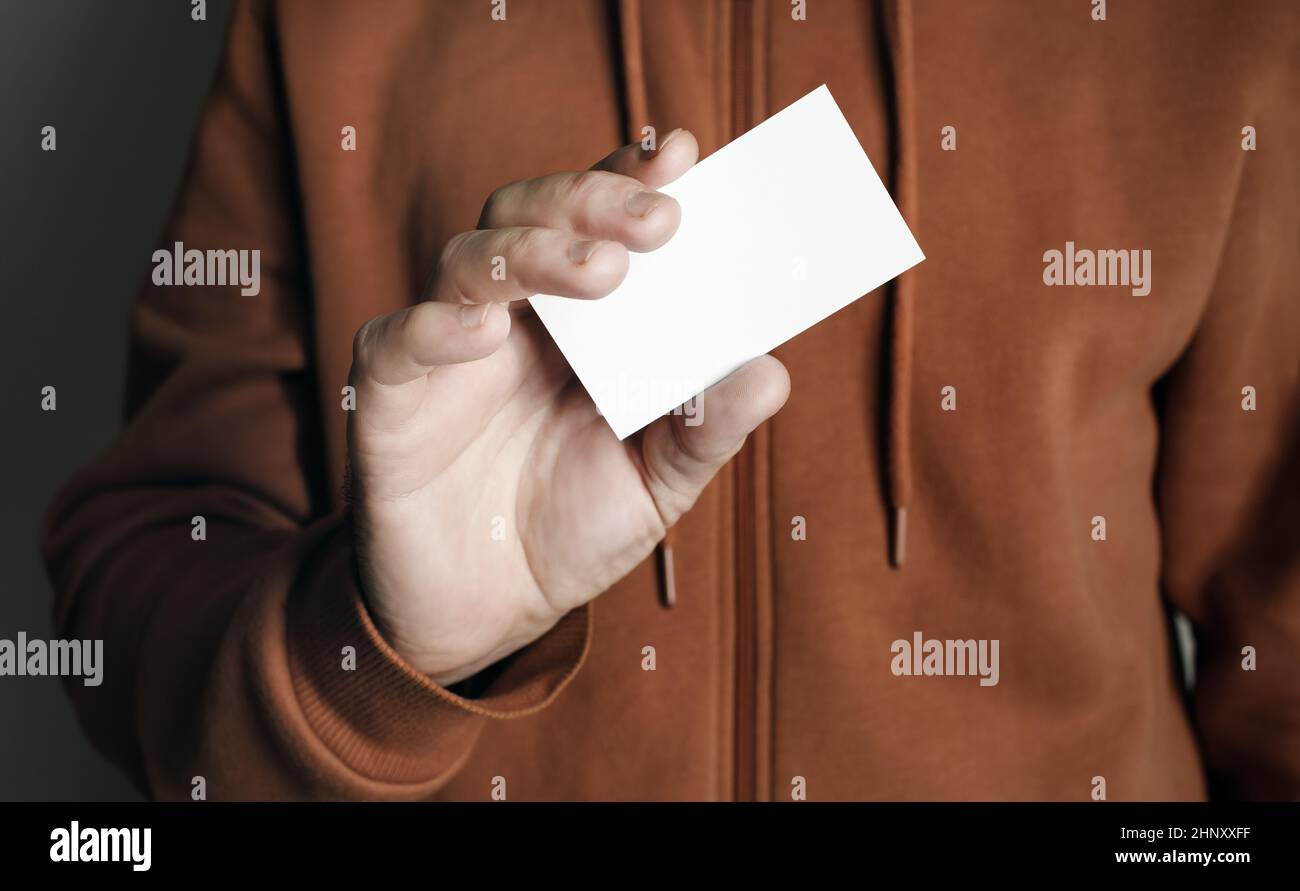 Mano dell'uomo che mostra il biglietto da visita bianco vuoto. Uomo con biglietto da visita. Foto Stock