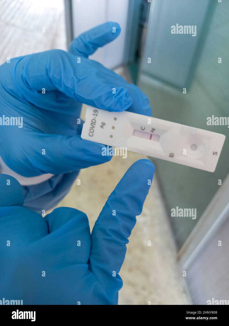 Operatore sanitario che punta il test rapido dell'antigene COVID-19. Risultato positivo Foto Stock