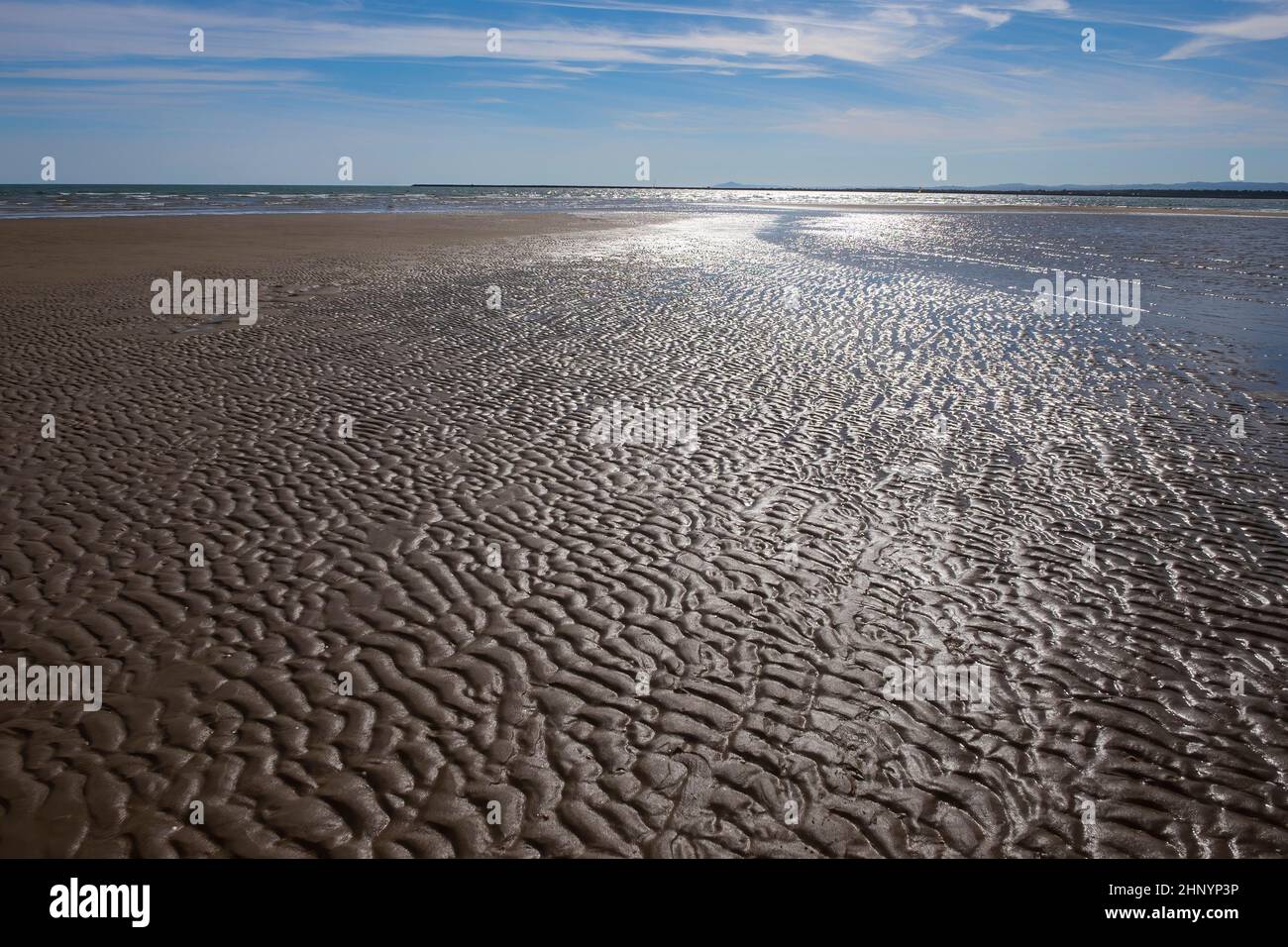 Segni e scanalature nella sabbia di una spiaggia a bassa marea con il mare e il cielo sullo sfondo, Isla Canela spiaggia, Ayamonte, Huelva, Spagna, stagcape Foto Stock