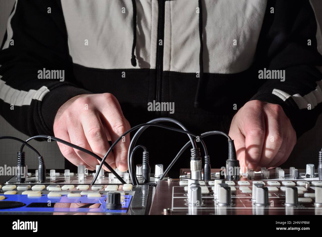 Lavora con strumenti musicali elettronici e sintetizzatori per generare e creare suoni per la musica elettronica in performance dal vivo Foto Stock