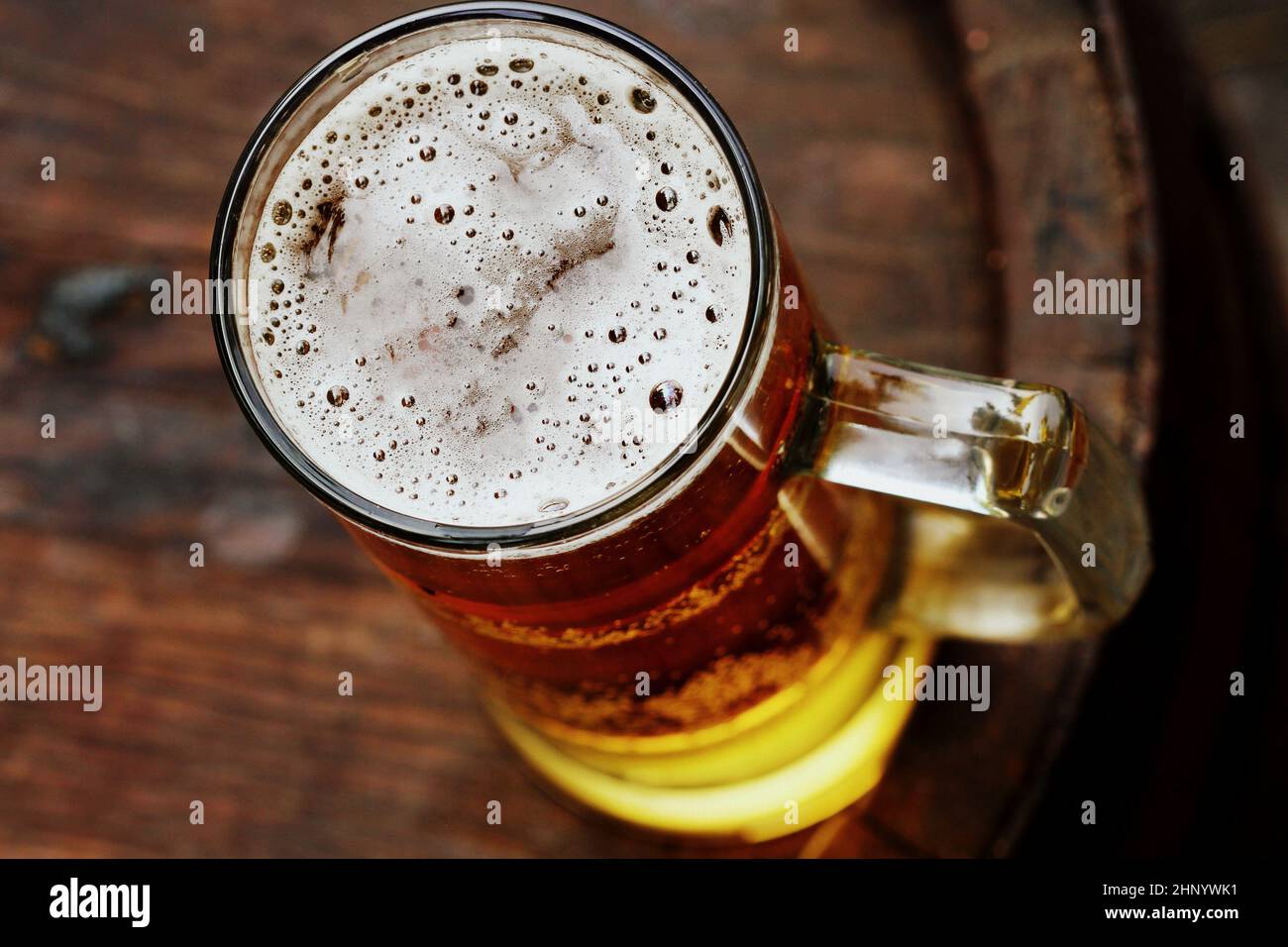 Bicchiere di birra su vecchio barile di legno. Foto Stock