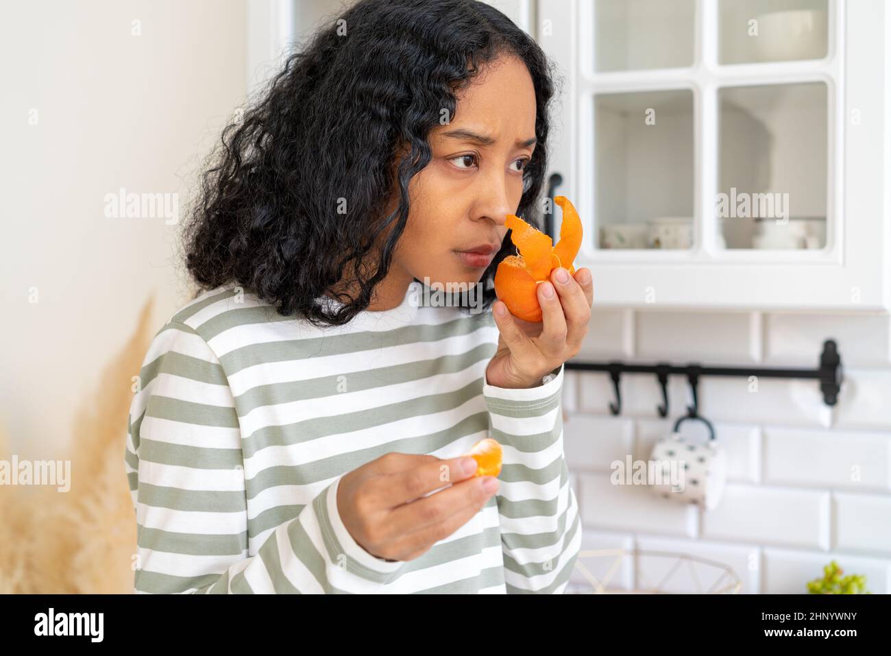 Donna afro-americana con sindrome post-covid. Concetto di perdita di odore a causa del virus covid-19 Foto Stock