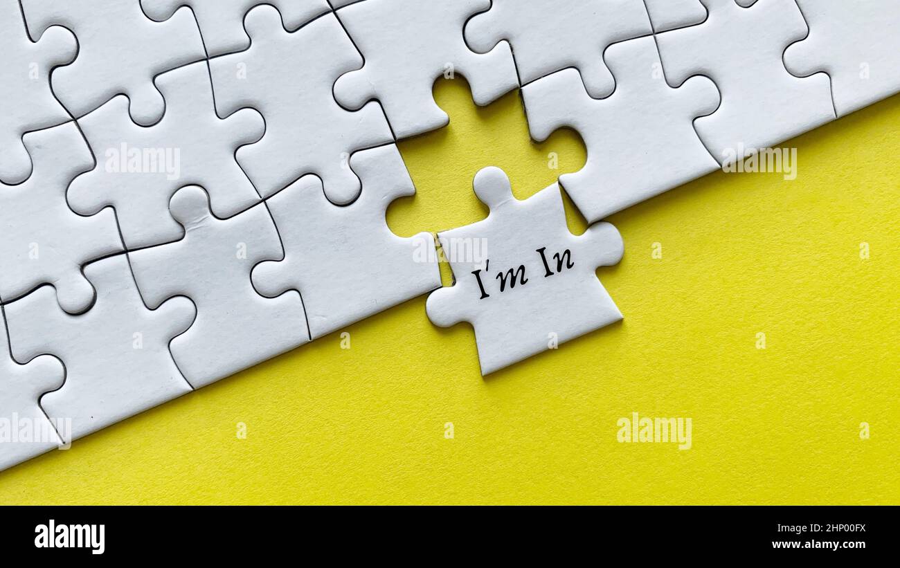 Vista dall'alto del testo - sono in. Su sfondo giallo di puzzle bianchi pezzi mancanti. Concettuale Foto Stock