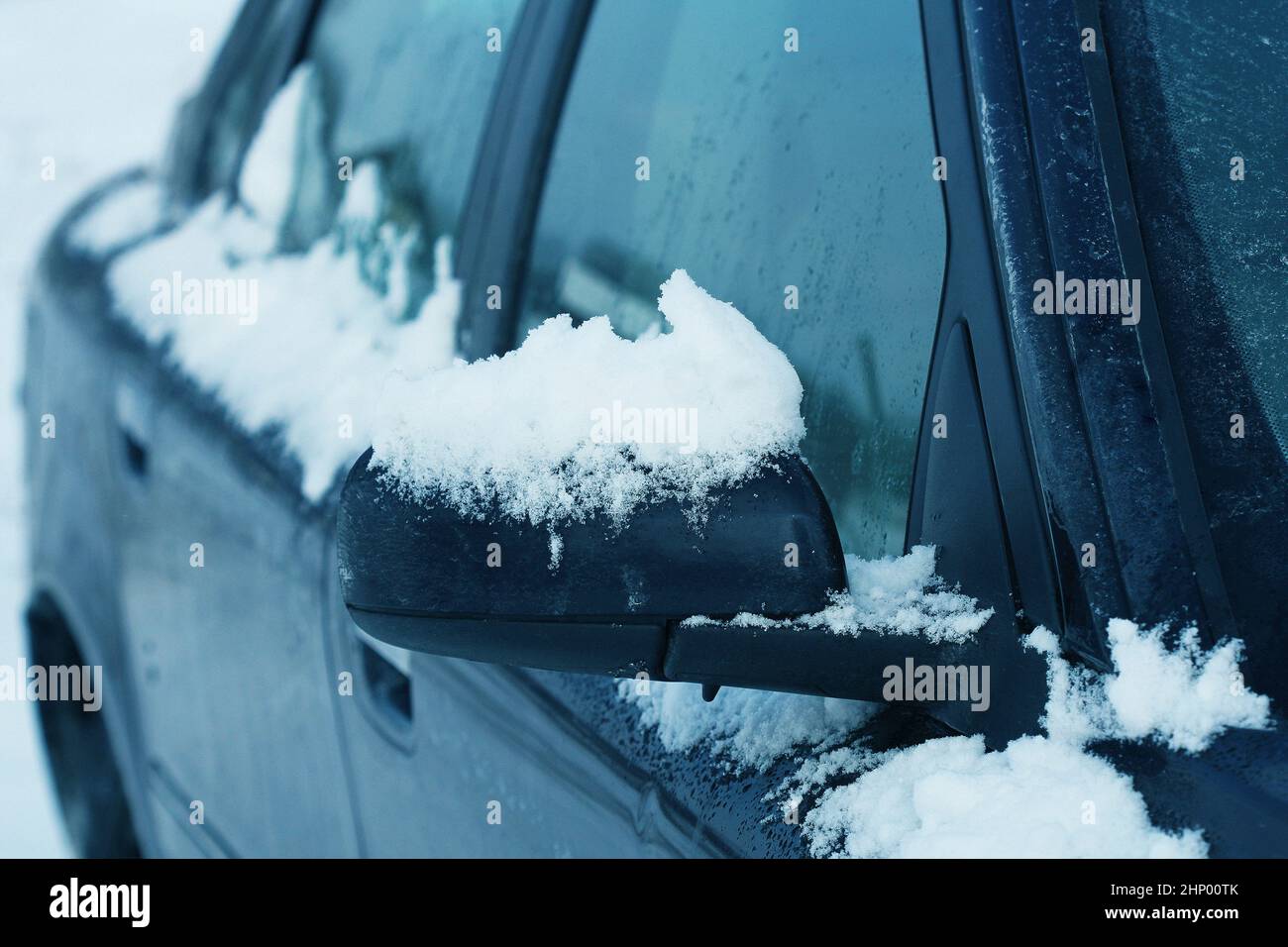 Specchietto laterale di auto coperto di neve in inverno, close up . Foto Stock