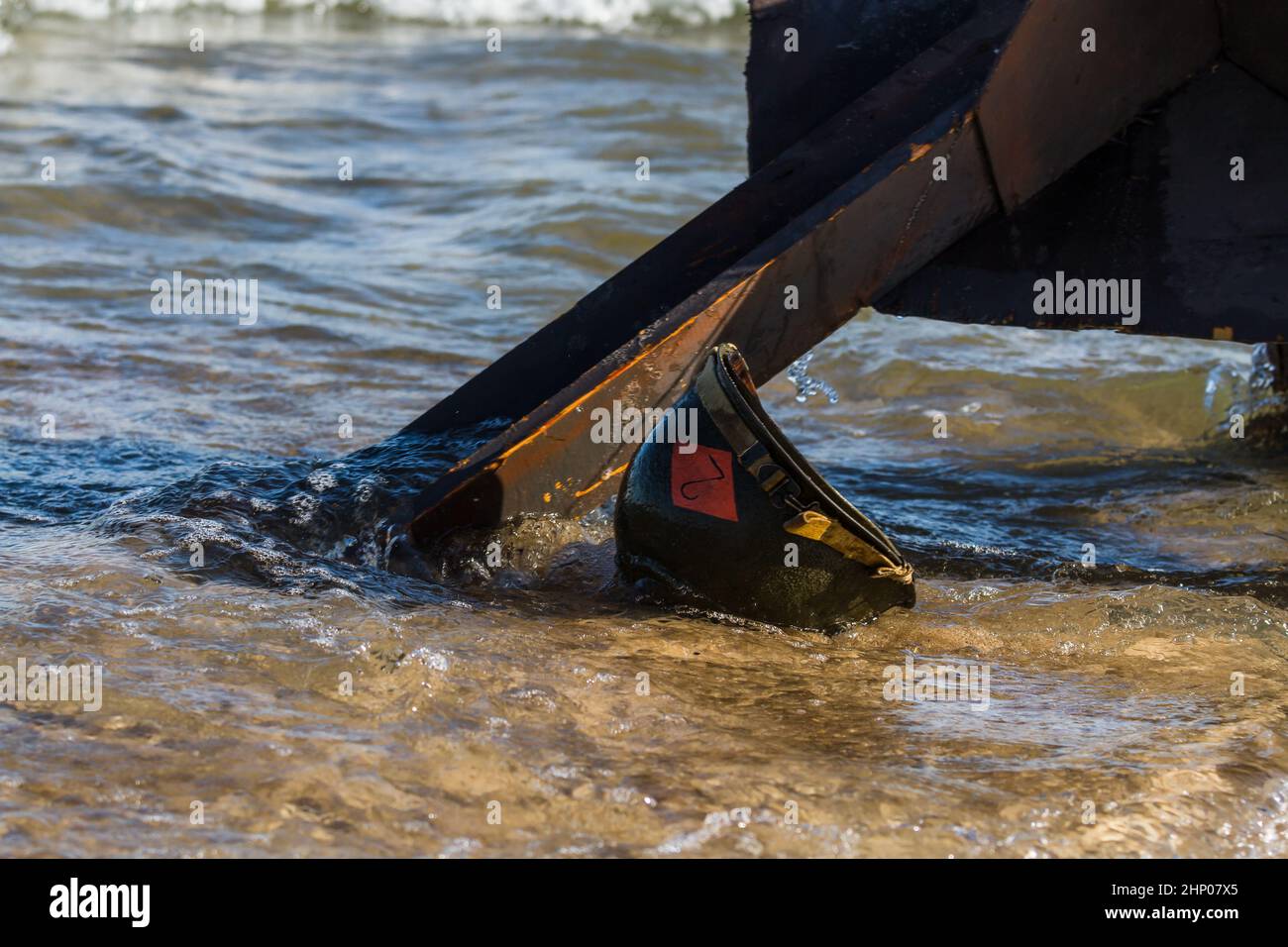 Wet Amcerian WW2 M1 casco lasciato dietro sulla spiaggia. Giorno dell'evento di rievocazione del D-Day. Hel, Polonia Foto Stock