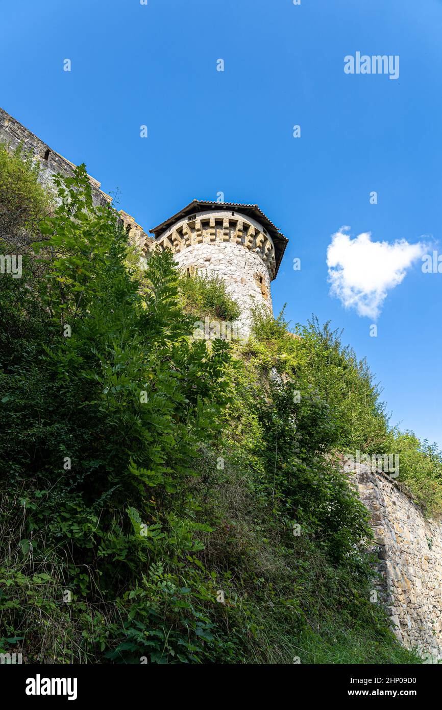 Massicce alte mura e una torre di un antico castello medievale Foto Stock