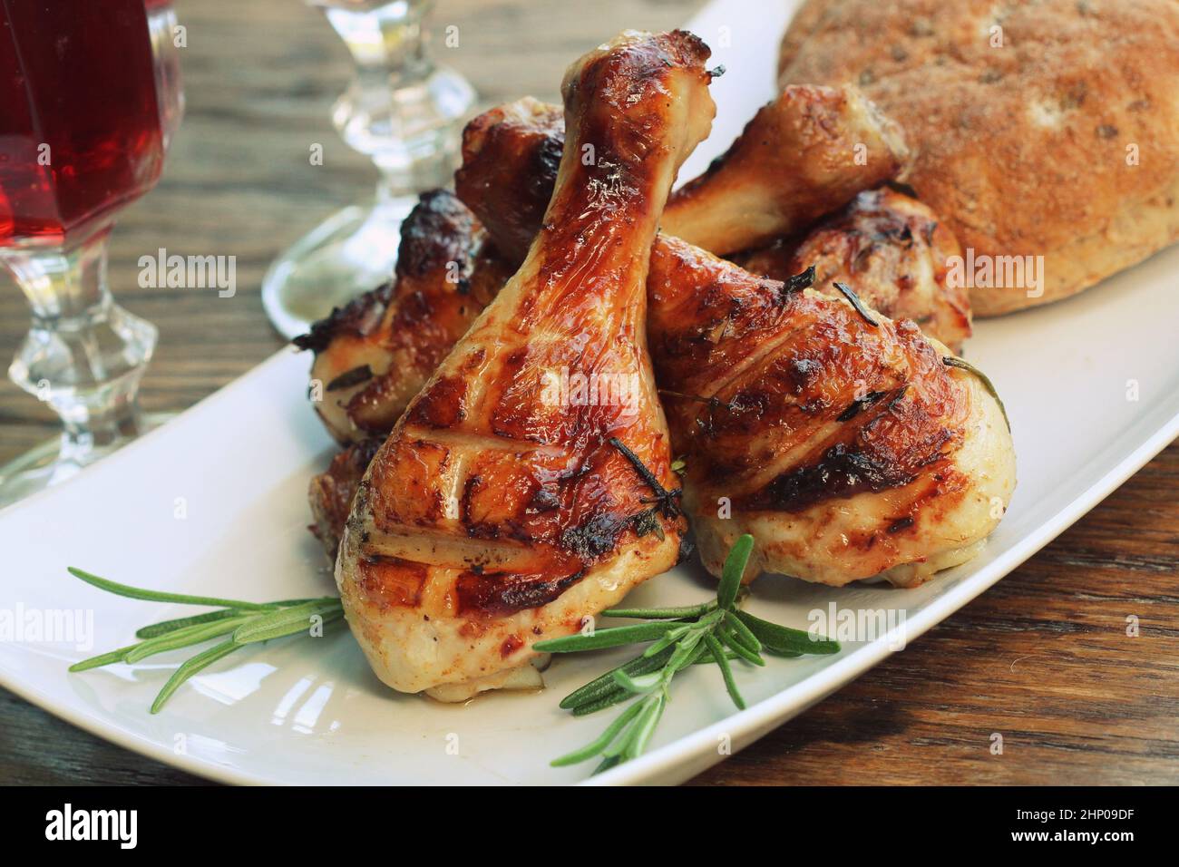 Grigliata di cosce di pollo con rosmarino servita su piastra bianca. La cena sfondo . Foto Stock