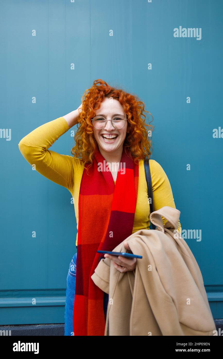 Pazza donna che si diverte davanti a uno sfondo blu Foto Stock