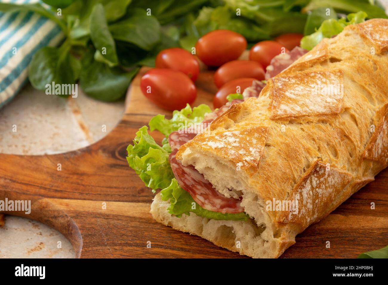 sandwich di salsiccia secca isolato su tavola di legno Foto Stock