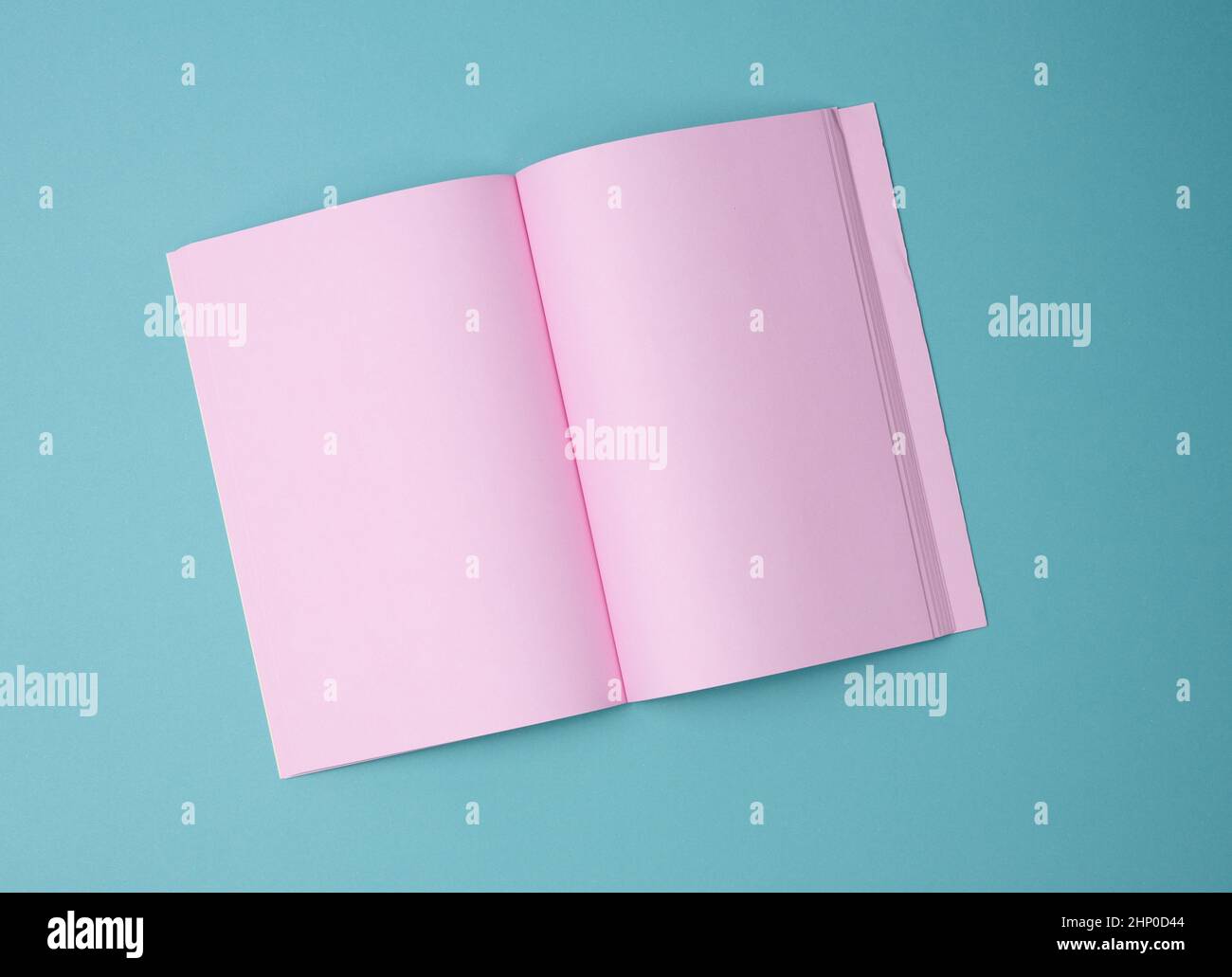 aprire il notebook con fogli rosa vuoti su sfondo blu, vista dall'alto Foto Stock