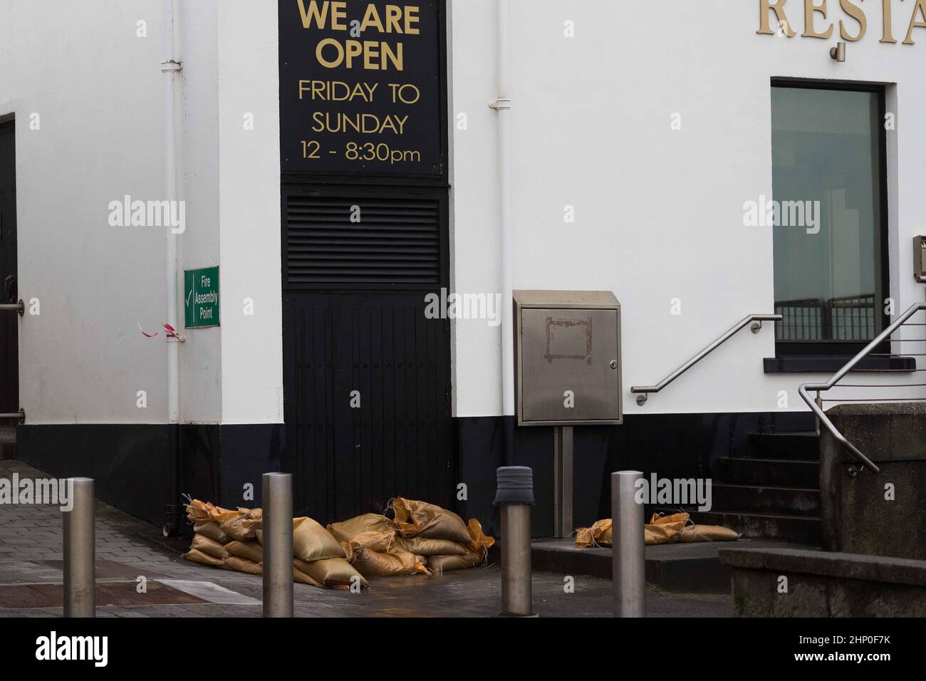 I sacchi di sabbia proteggono una proprietà a Lahinch, Co Clare, mentre Storm Eunice continua a infuriare in tutta l'Irlanda. Più di 55.000 case, fattorie e aziende erano senza potere sull'isola il venerdì mattina, mentre la tempesta seguiva verso est in tutta la Repubblica. Le contee di Cork, Kerry e il sud del paese hanno portato il peso della tempesta maggiore finora, che ha portato venti e neve alti a parti dell'isola. Data immagine: Venerdì 18 febbraio 2022. Foto Stock