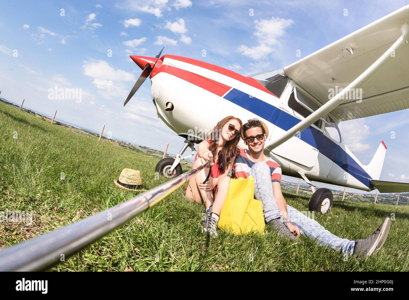 Giovane coppia che prende selfie a leggero aeroplano - Happy People imbarco su aereo escursione - alternative avventura vacanza concetto - caldo giorno Foto Stock