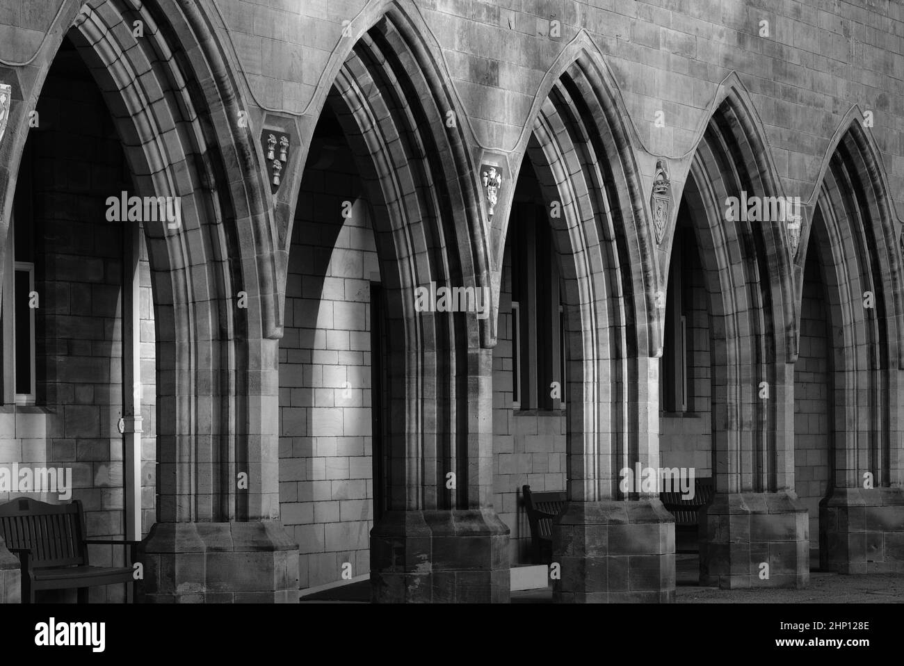 Una fotografia in bianco e nero degli archi in pietra e della passerella rivestita di chiostro che fanno parte della Elphinstone Hall, Aberdeen University, Aberdeen, Scozia. Foto Stock