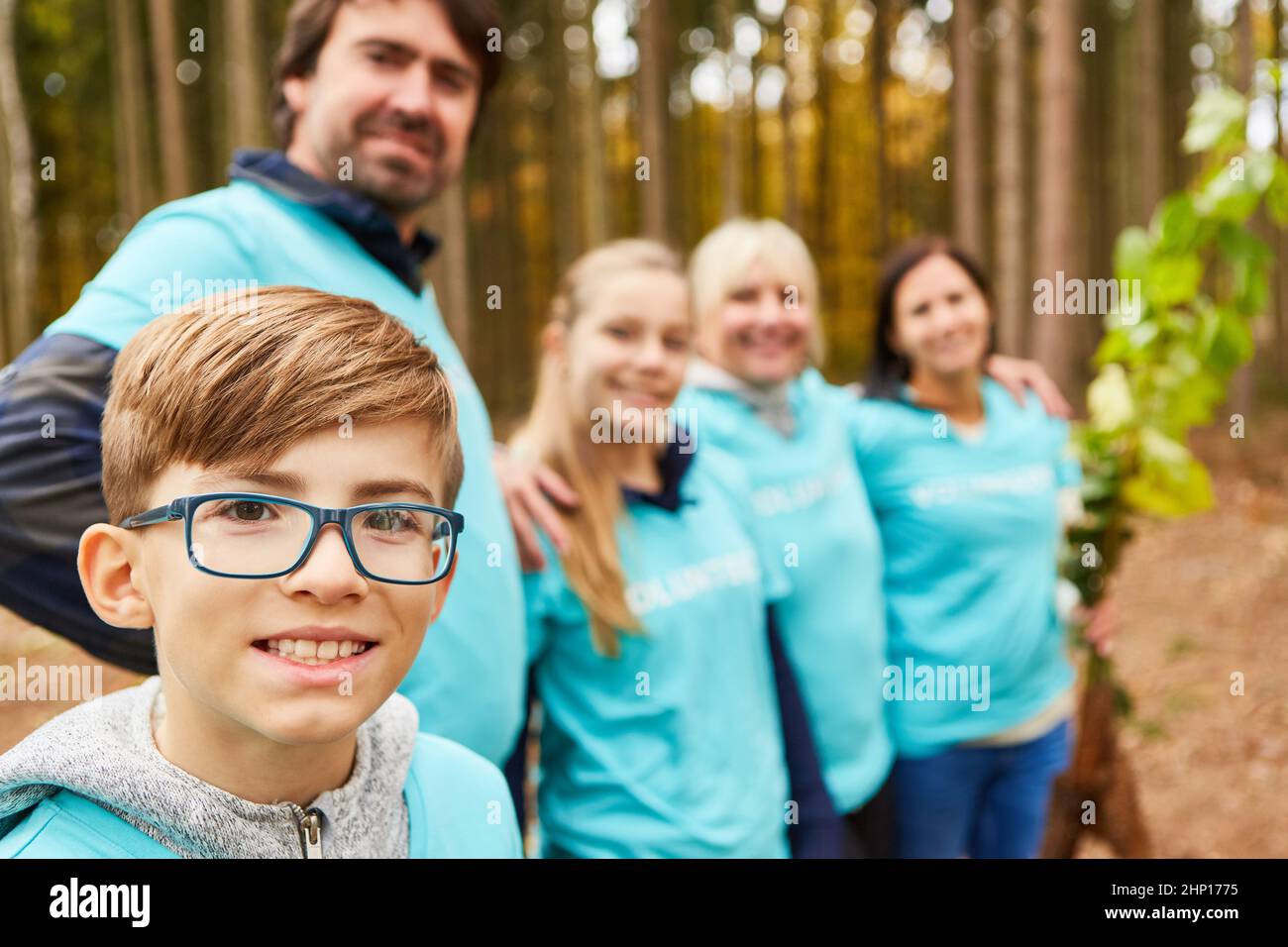 Giovani e familiari come ambientalisti e volontari nella foresta per un rimboschimento sostenibile Foto Stock