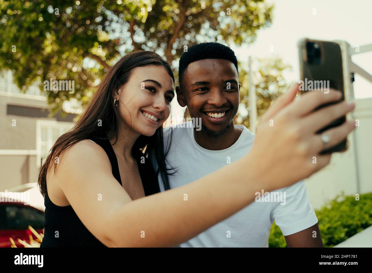 Coppia biraciale che prende selfie al telefono al college Foto Stock