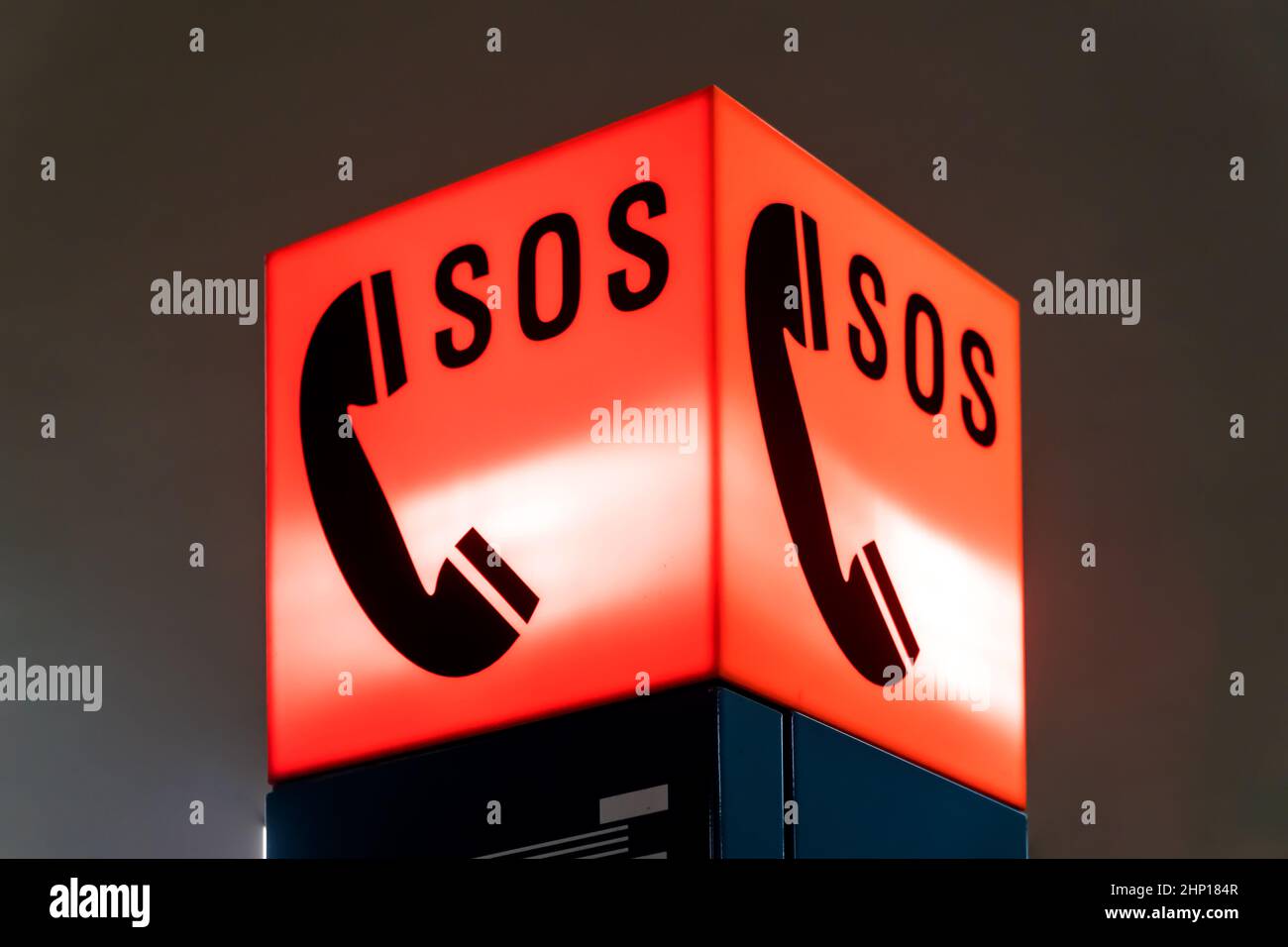 Segnale SOS rosso illuminato con telefono in dettaglio Foto Stock