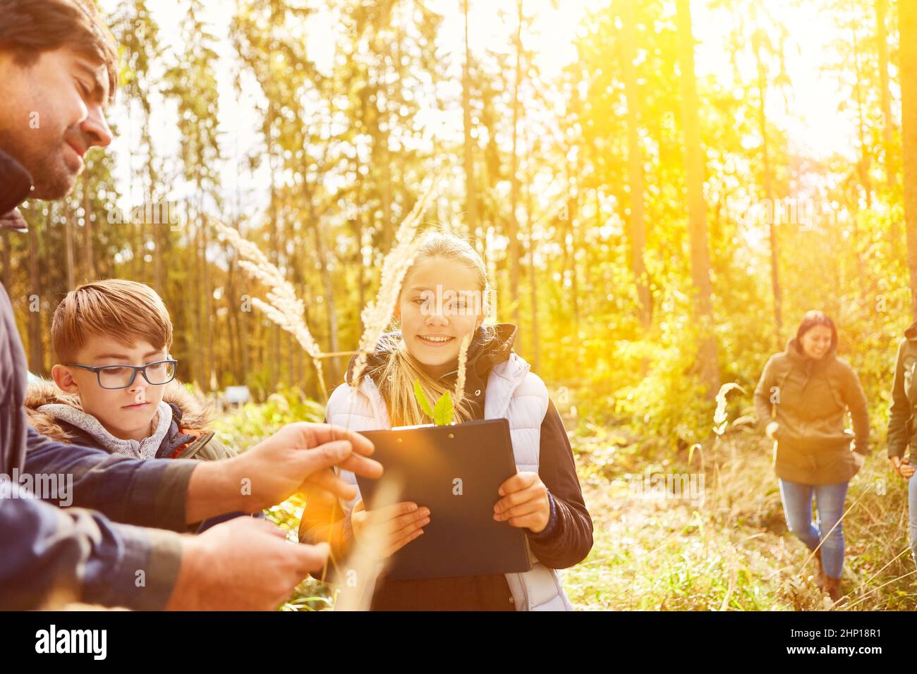 Bambini a lezioni di storia naturale nella foresta con i foresters in estate Foto Stock