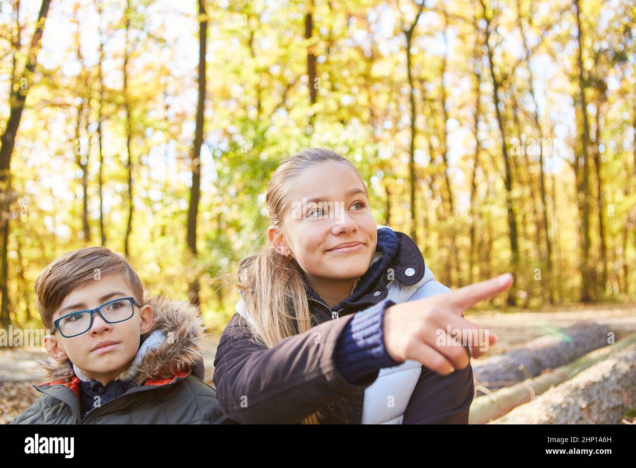 Due bambini nella foresta in un viaggio o un'escursione puntano la direzione con il dito Foto Stock