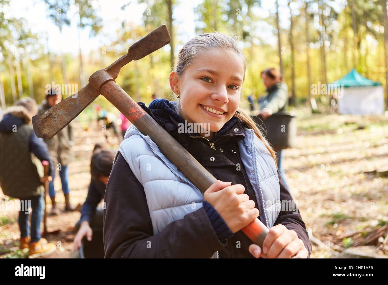Ragazza allegra come attivista per la conservazione della natura e la protezione ambientale in una campagna di rimboschimento Foto Stock