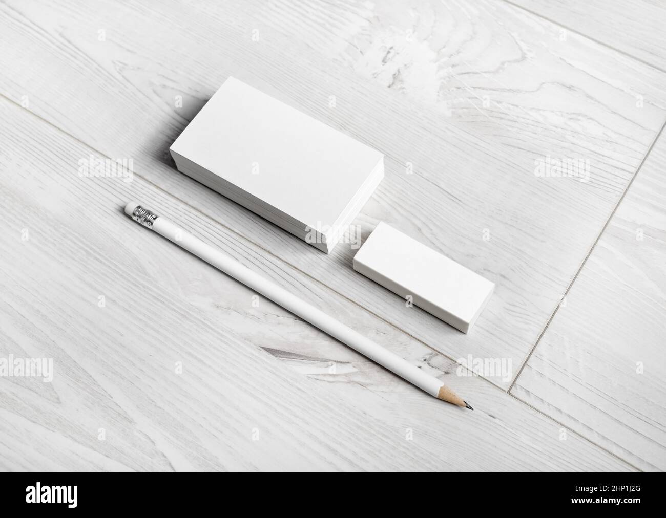 Biglietti da visita vuoti, matita e gomma su sfondo di legno. Modello per ID. Foto Stock
