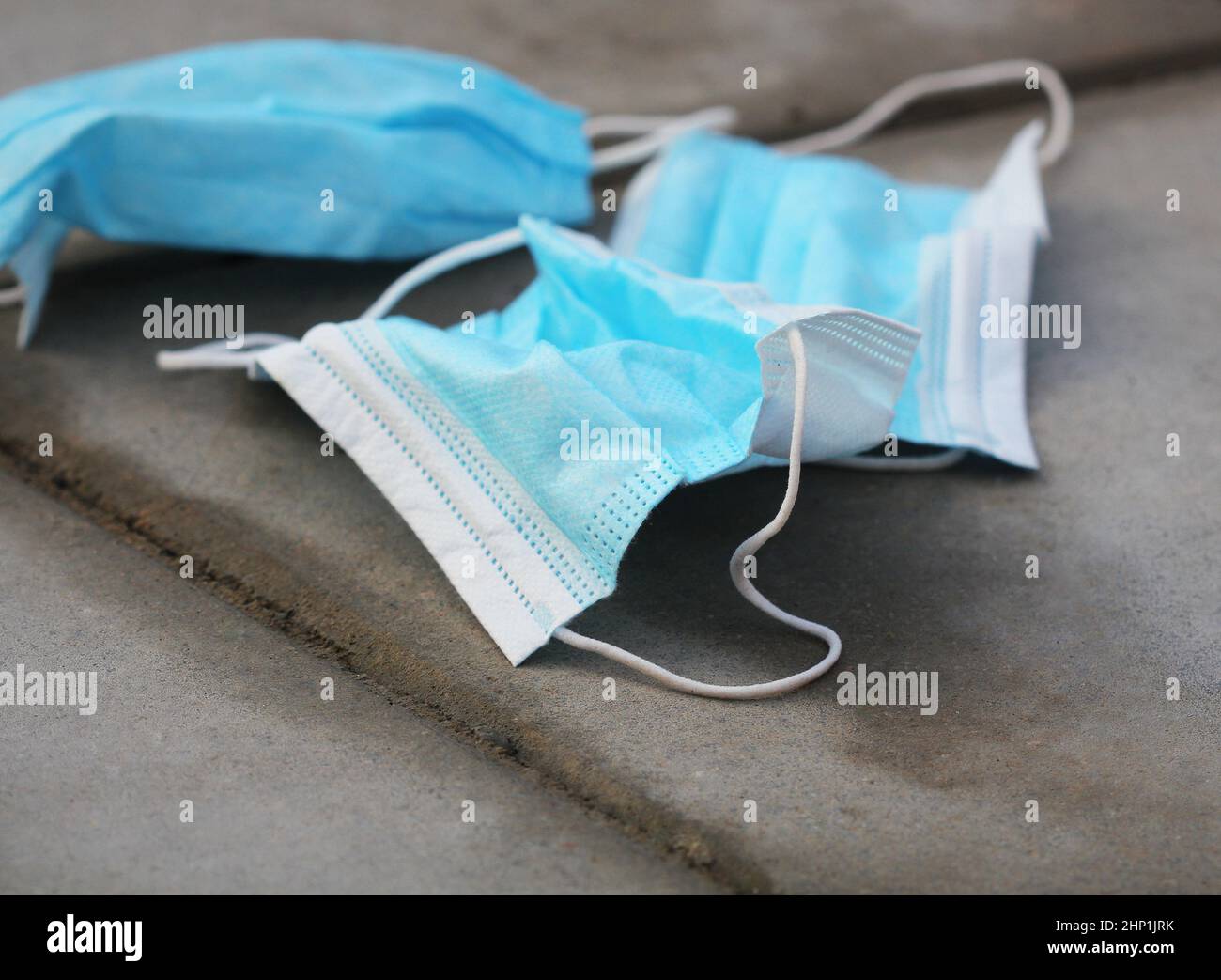Maschera medica usata gettata fuori sui rifiuti di strada disseminati nella città scartata dopo un uso. DPI sporchi non riutilizzabili. Foto Stock