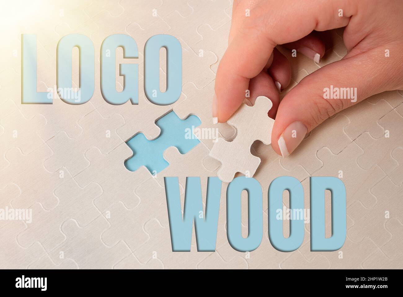 Segno che mostra legno del logo, parola per disegno riconoscibile o simbolo di una società inscritto su legno costruire un bianco incompiuto Jigsaw Puzzle Wi Foto Stock