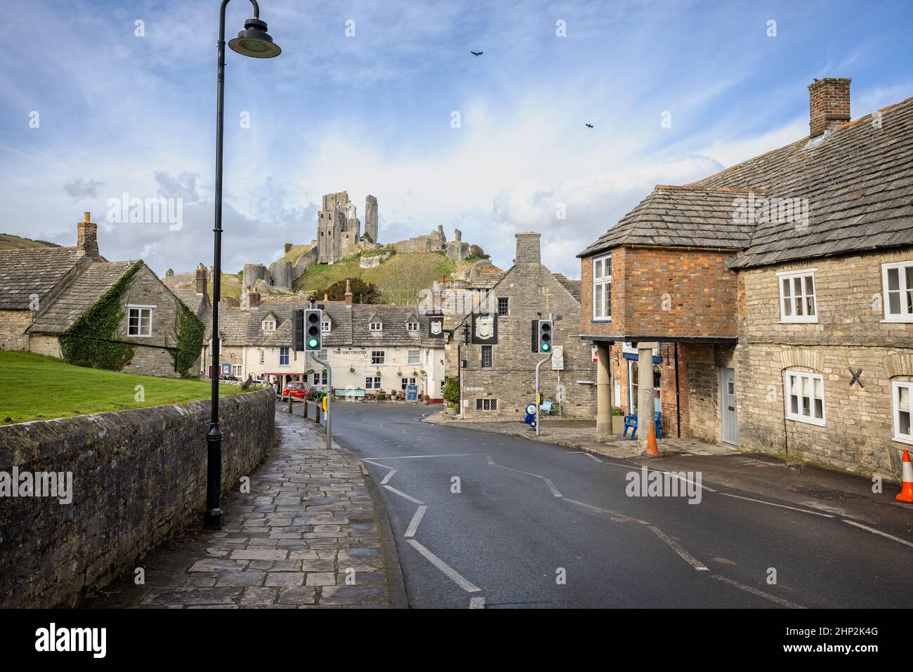 I pub Bankes Arms e Greyhound Inn con le rovine del castello di Corfe in background, su East Street a Corfe, Dorset, Regno Unito, il 18 febbraio 2022 Foto Stock