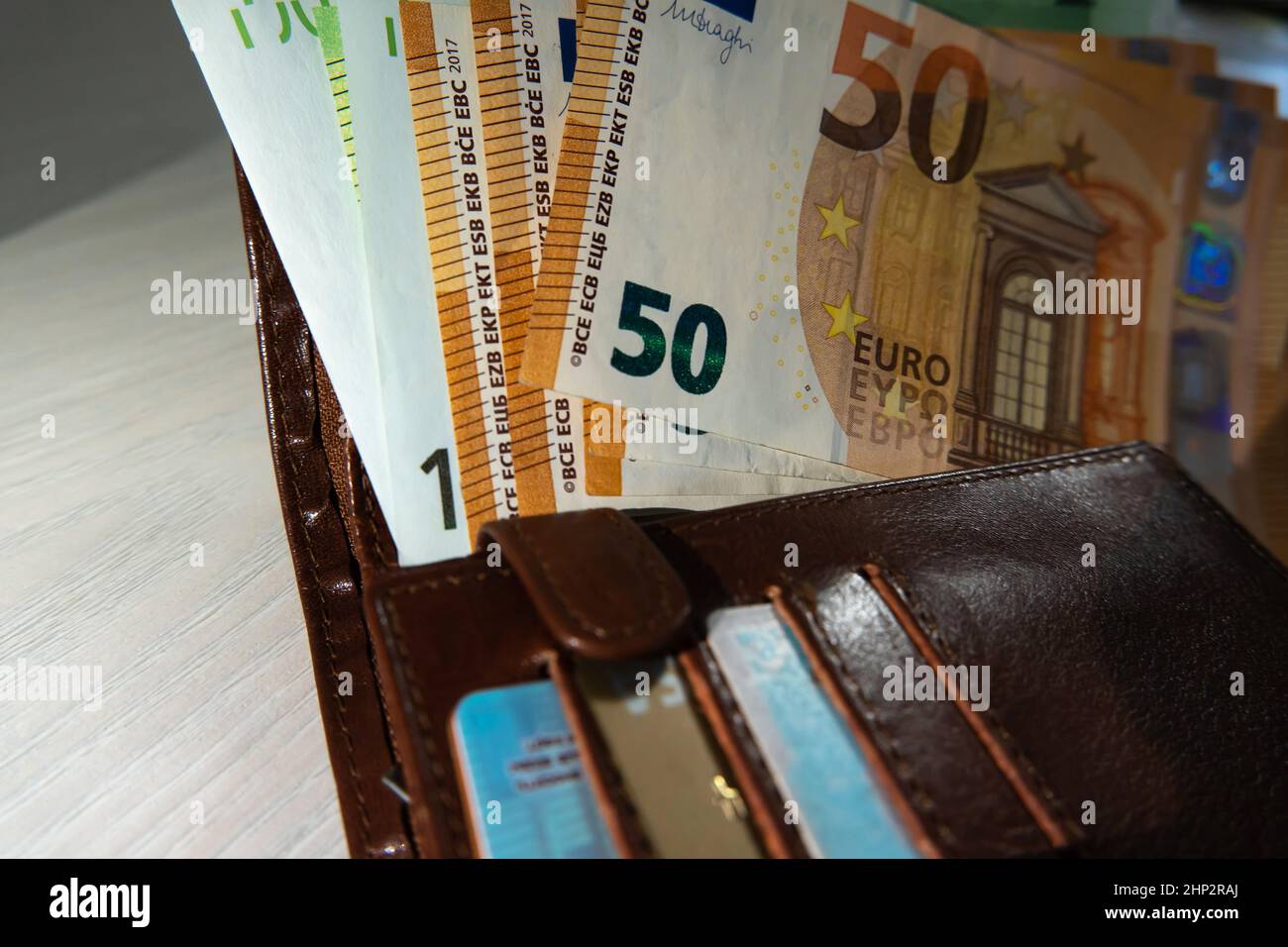 I contanti in euro sono sul portafoglio con le carte di credito. Un sacco di soldi. Calcolo delle donazioni finanziarie. Contabilità dei mezzi di pagamento e dei salari nell'UE Foto Stock