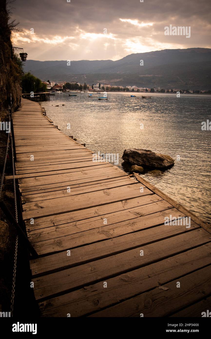 Pontile in legno su un lago in una mattina nuvolosa. Foto Stock