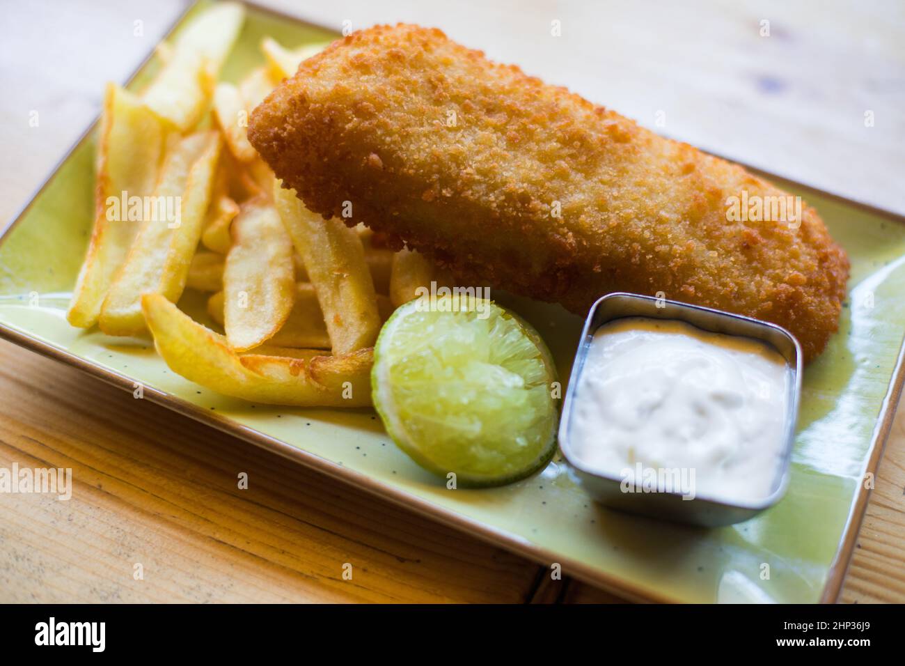 Pesce tradizionale britannico e patatine fritte con salsa tartara su un piatto. Foto Stock