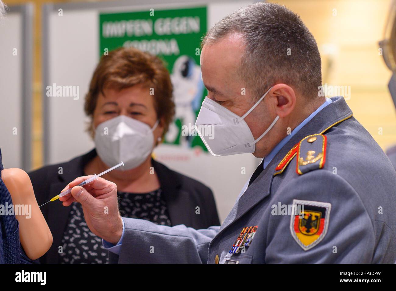 Magdeburg, Germania. 18th Feb 2022. 18 febbraio 2022, Sassonia-Anhalt, Magdeburg: Carsten Breuer (r), capo dello staff della Cancelleria federale della Corona, prova la vaccinazione su un tampone di silicone. Petra Grimm-Benne (M, SPD), Ministro del lavoro, degli affari sociali, della salute e dell'uguaglianza dello Stato di Sassonia-Anhalt, si trova accanto al maggiore generale delle forze armate tedesche. Tali cuscini sono utilizzati nelle sessioni di addestramento di vaccinazione. Prima di visitare la farmacia dove le vaccinazioni inizieranno nelle prossime settimane, il maggiore generale delle forze armate tedesche ha incontrato il Ministro Presidente della Sassonia-Anhal Foto Stock