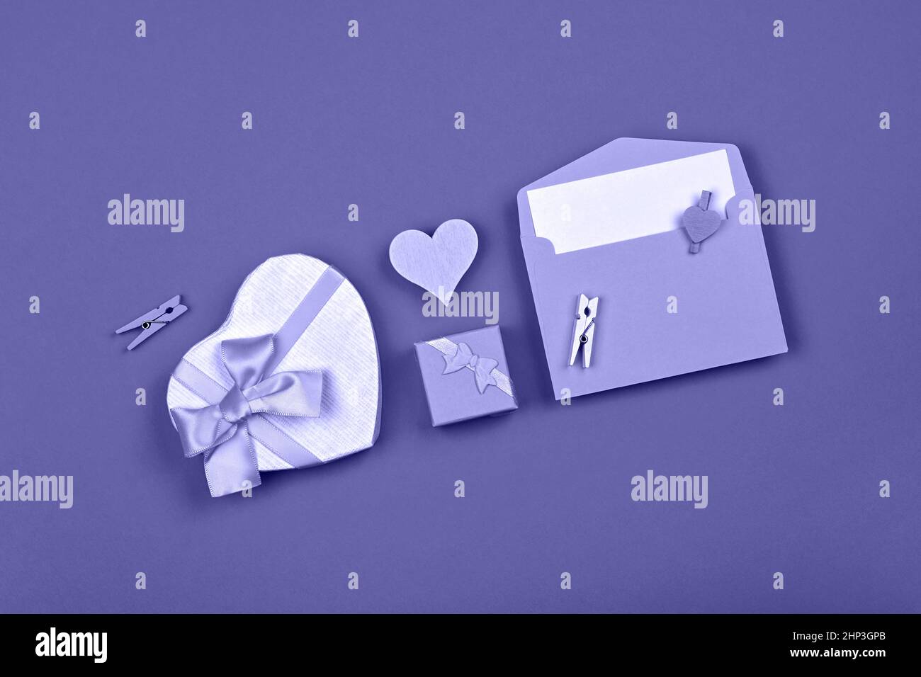 Modello valentino di scatole regalo a forma di cuore con arco a nastro e busta su sfondo lavanda, molto peri, colore dell'anno 2022, piatto, elevato t Foto Stock