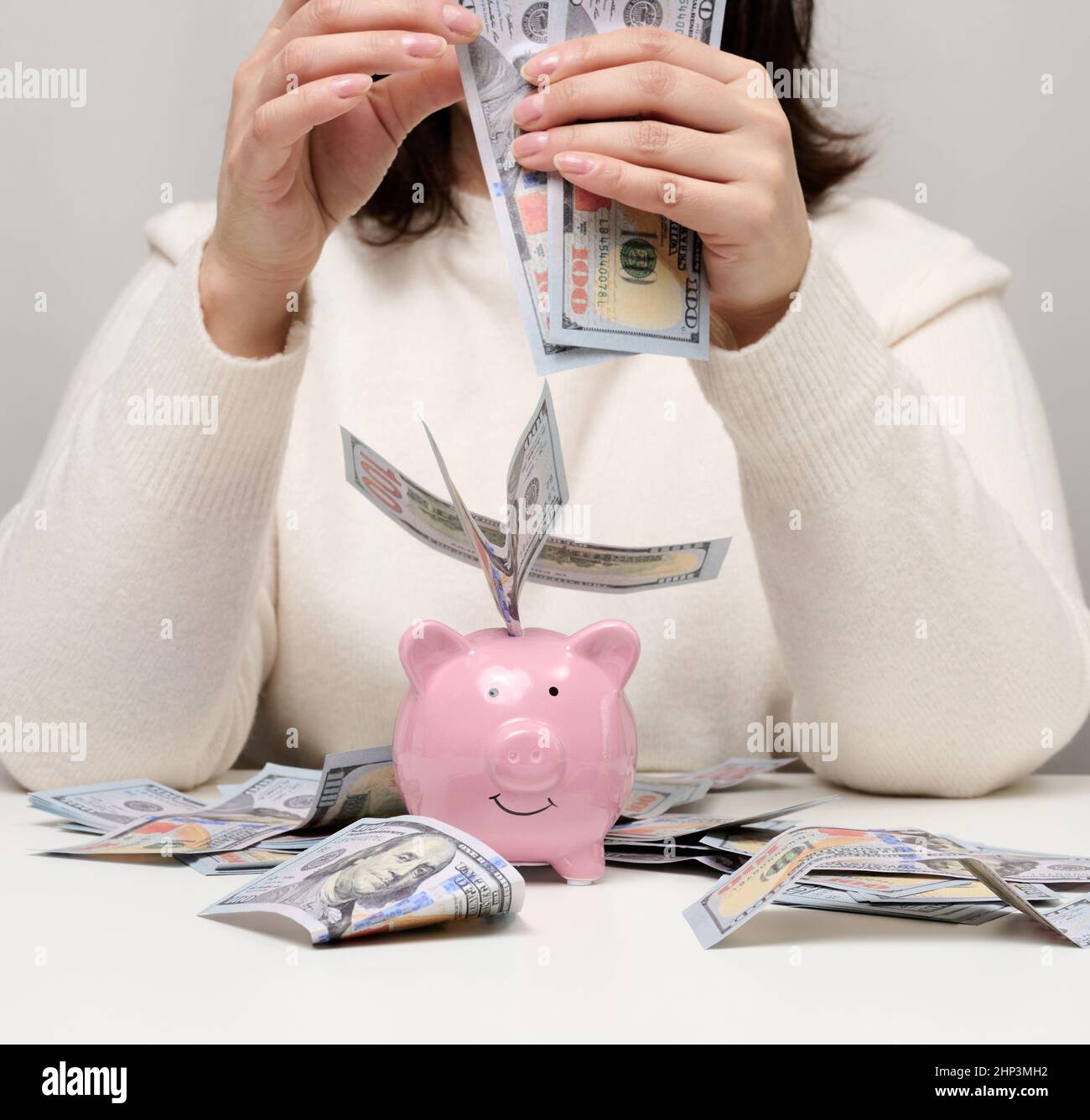 Rosa ceramico Piggy banca e donna con carta americana denaro. Concetto di ricchezza, affare, accumulazione. Elevato margine di profitto Foto Stock