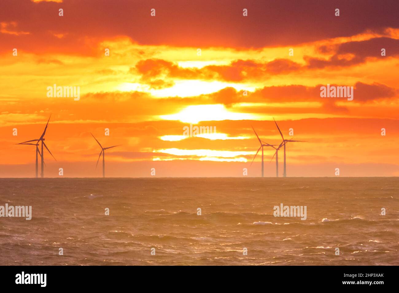 Sunrise all'industria della decarbonizzazione attività di mulini a vento per le energie rigenerative. Energie rinnovabili pulite che prevengono il cambiamento climatico. Foto Stock
