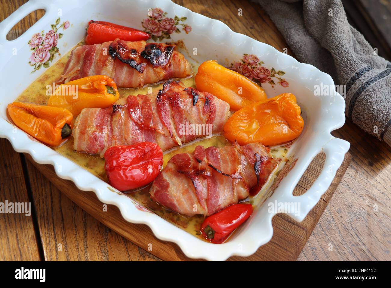 Cena sfondo. Petto di pollo alla griglia avvolto in pancetta in padella da cucina su tavola rustica in legno. Vista dall'alto . Foto Stock