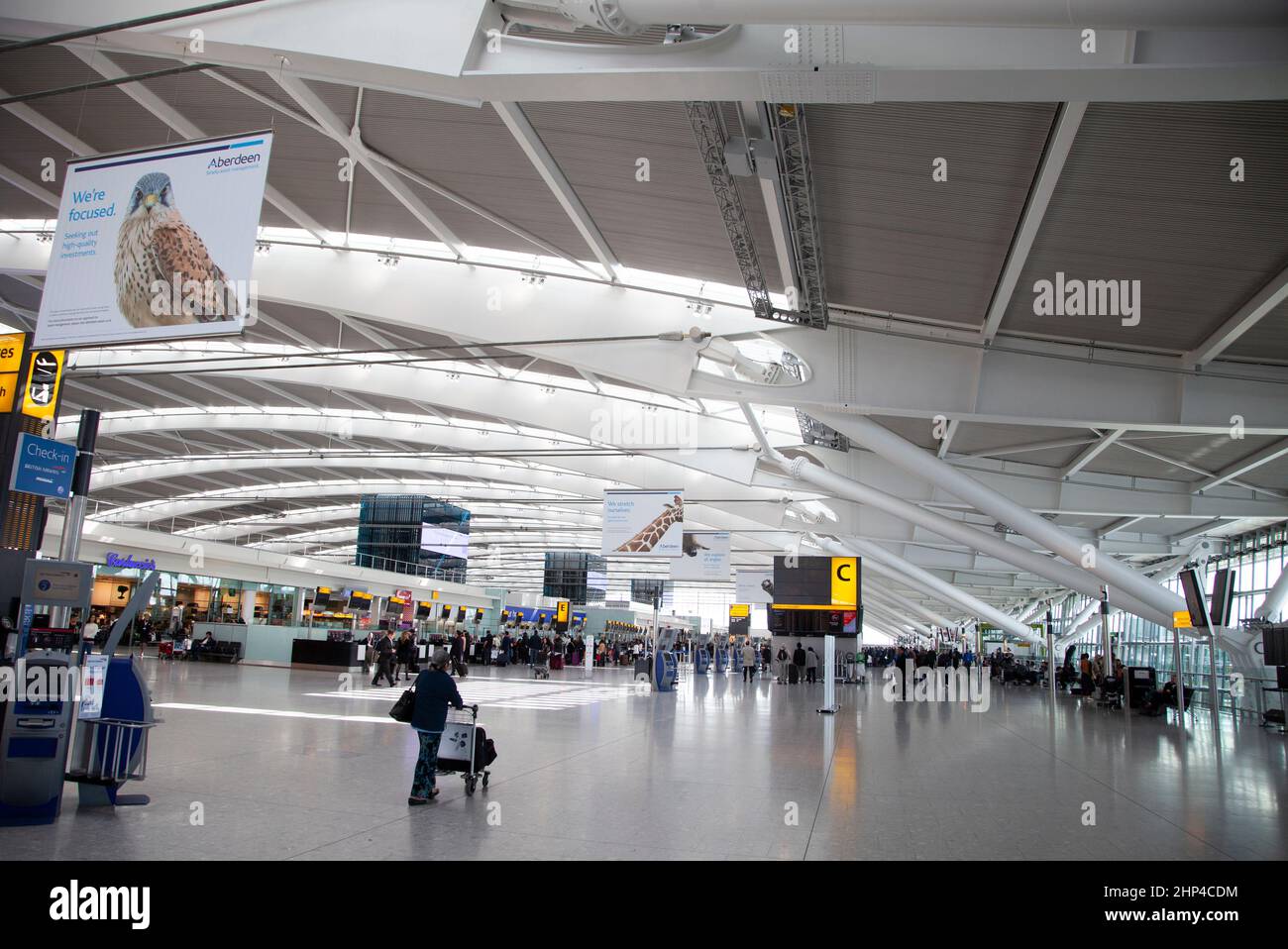 Passeggeri in un terminal trafficato dell'aeroporto di Heathrow a Londra, Regno Unito Foto Stock