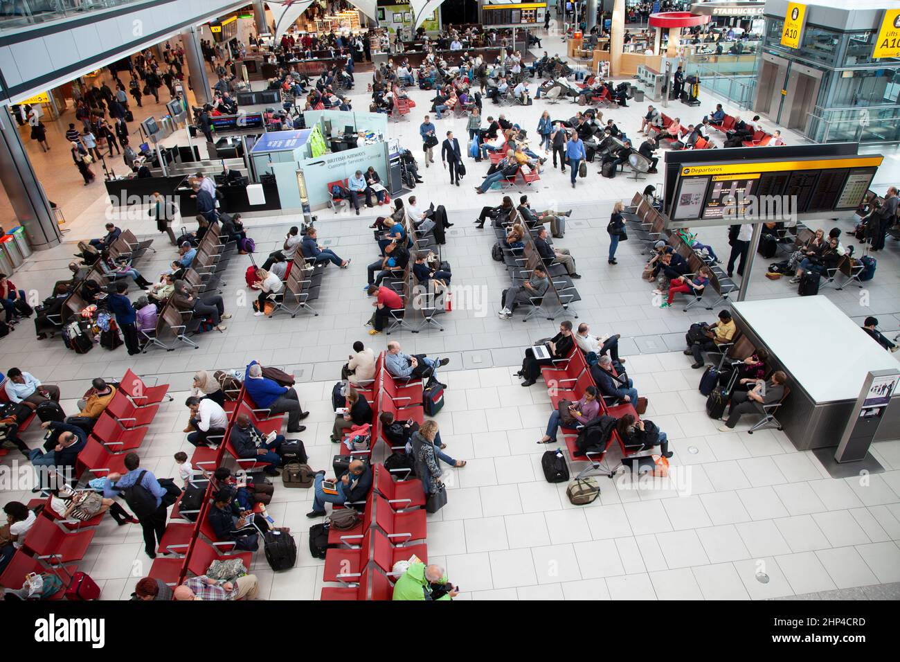 Passeggeri in un terminal trafficato dell'aeroporto di Heathrow a Londra, Regno Unito Foto Stock