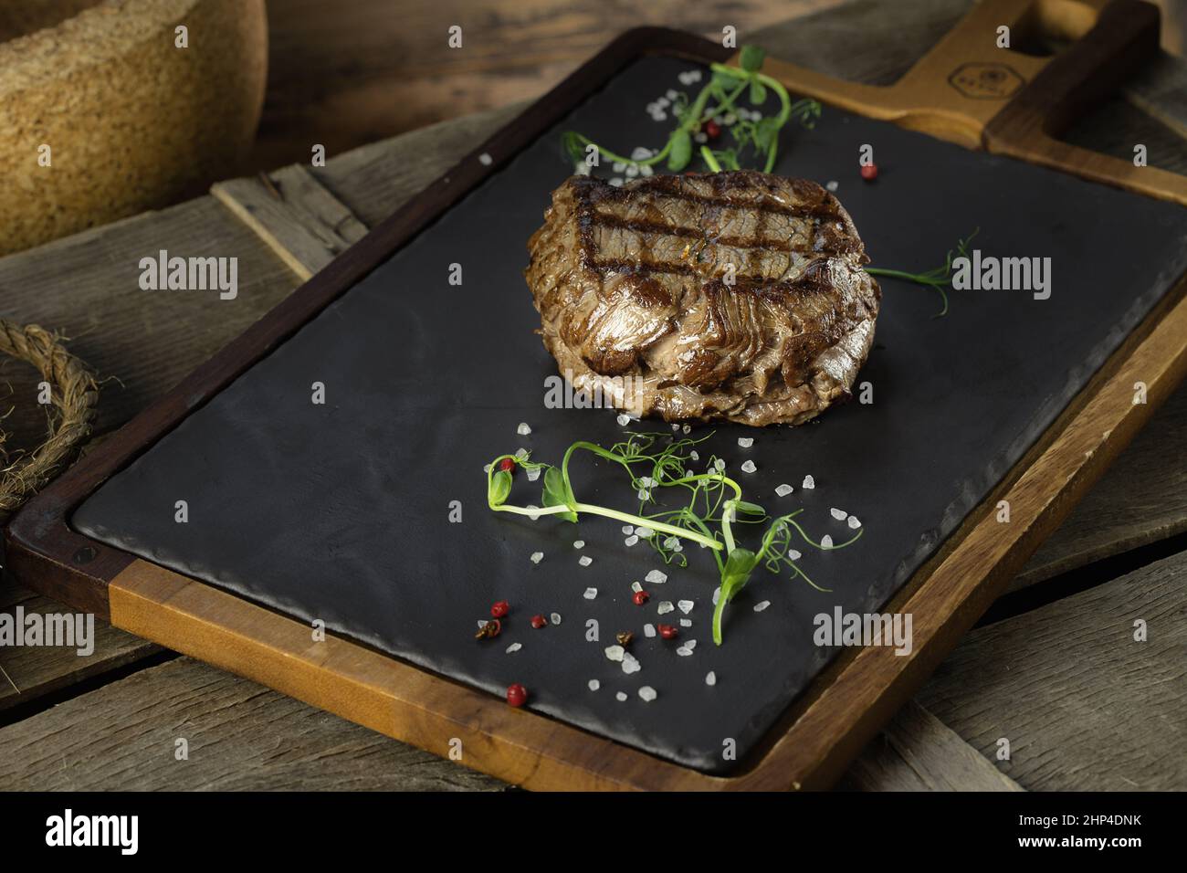 filetto mignon bistecca lezhin su un basamento di pietra e legno, decorato con microgreens e grandi cristalli di sale, stile rustico, primo piano Foto Stock