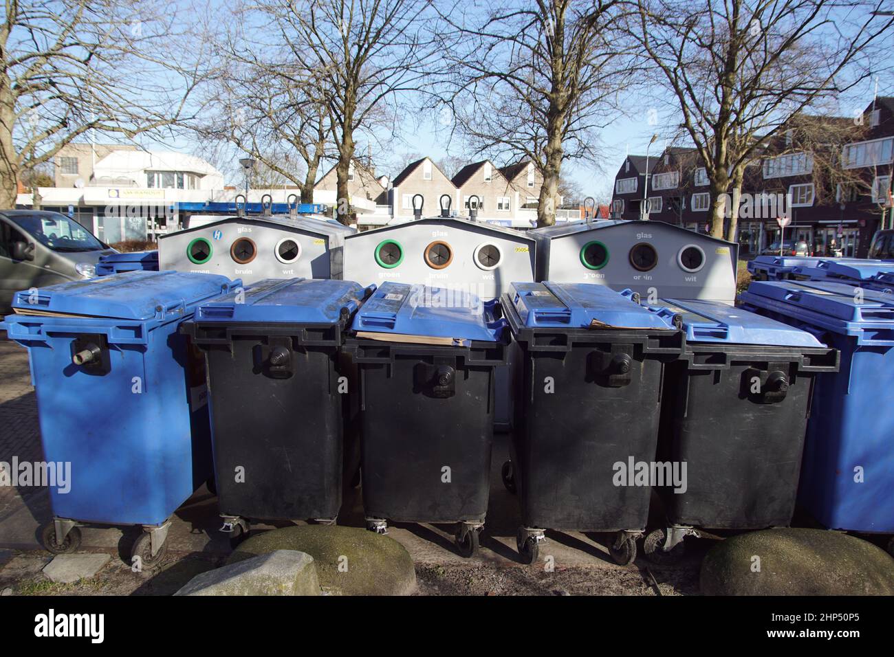 Contenitori di plastica per la raccolta della carta di scarto nel villaggio olandese di Bergen. Dietro di loro contenitori per la raccolta del vetro. Paesi Bassi, febbraio. Foto Stock