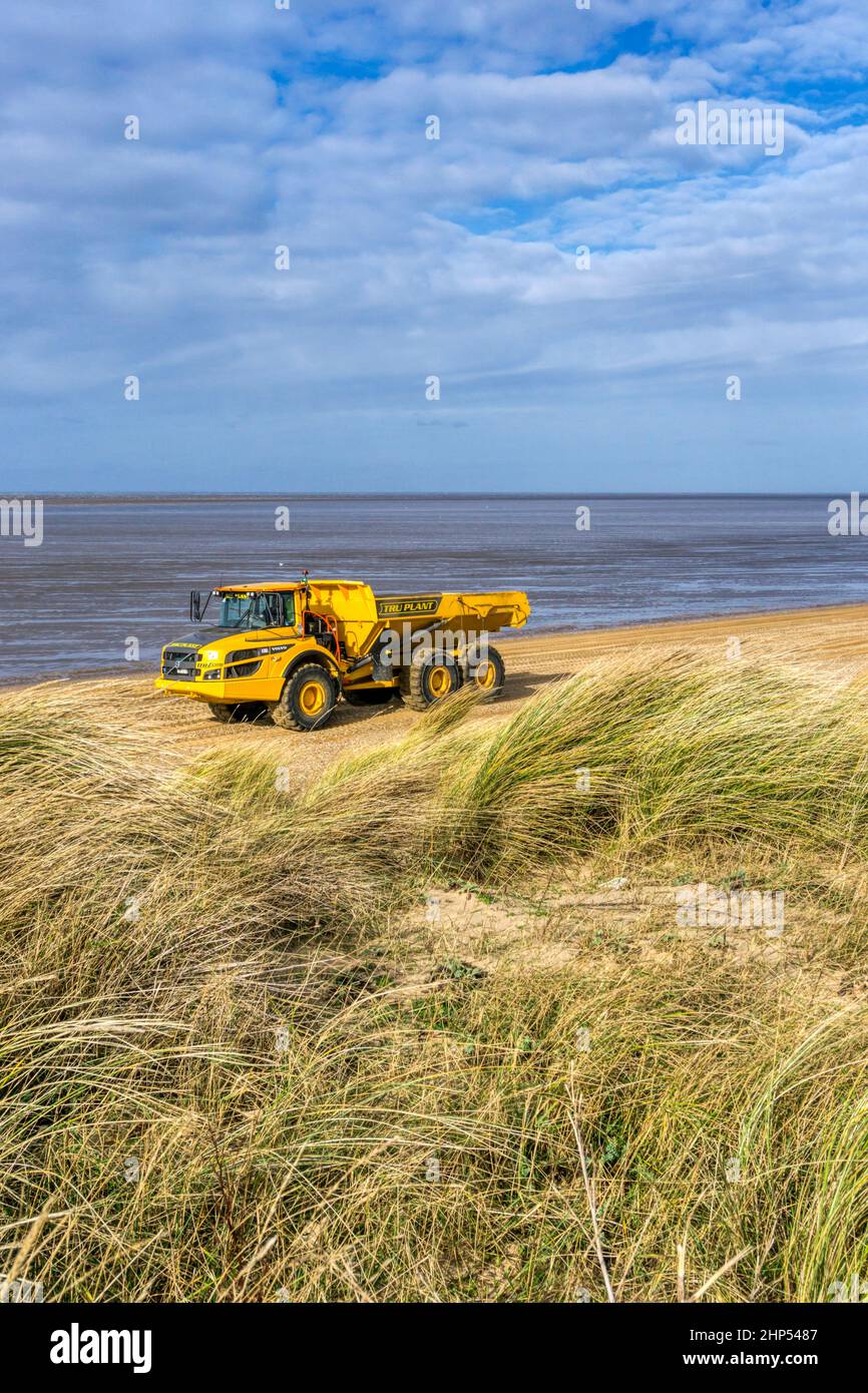 Autocarro Volvo A30G che esegue lavori di restauro della linea costiera sulla riva del lavaggio a Snettisham spiaggia, Norfolk. Foto Stock