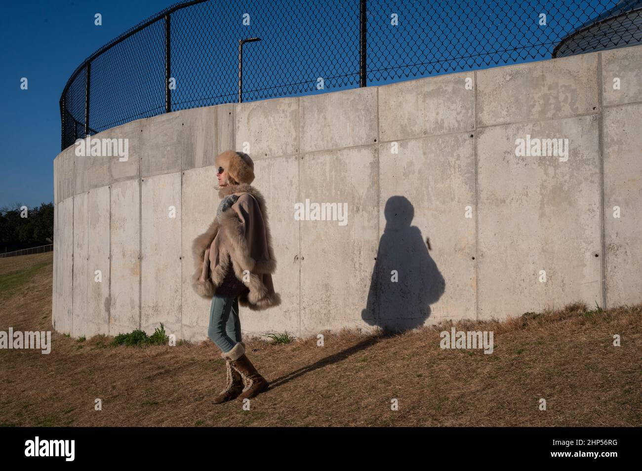 Austin, Texas, Stati Uniti. 18 Febbraio, 2022. Una donna cammina per lavorare impacchettato per il freddo. (Autorizzazione concessa). Austin si sveglia a temperature gelide. Alba su Murchison Hill nel nord-ovest di Austin, mentre le persone vestite per il freddo fanno il loro modo di lavorare. . Credit: Sidney Bruere/Alamy Live News Foto Stock