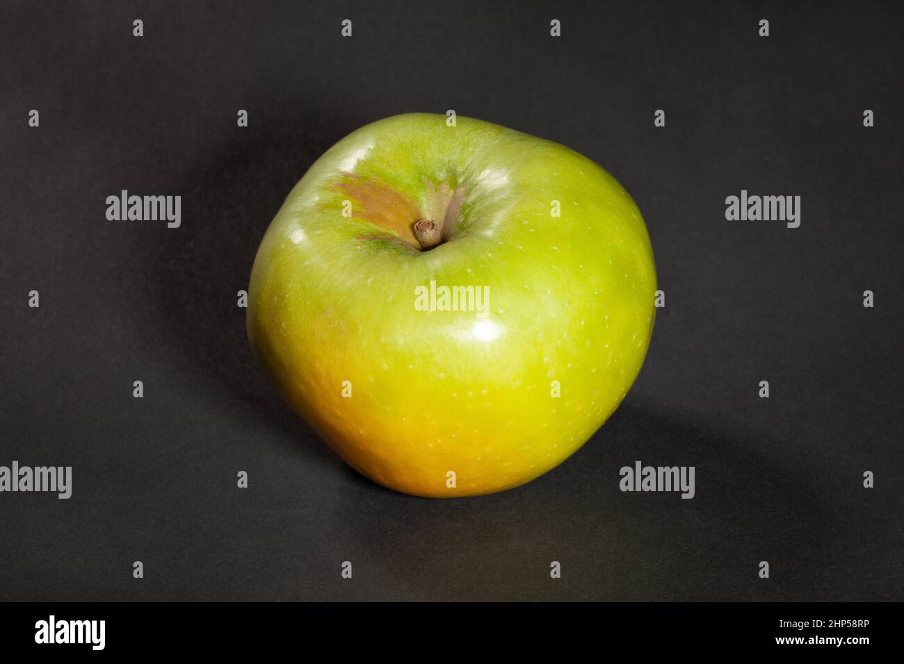mela granny smith su sfondo nero Foto Stock