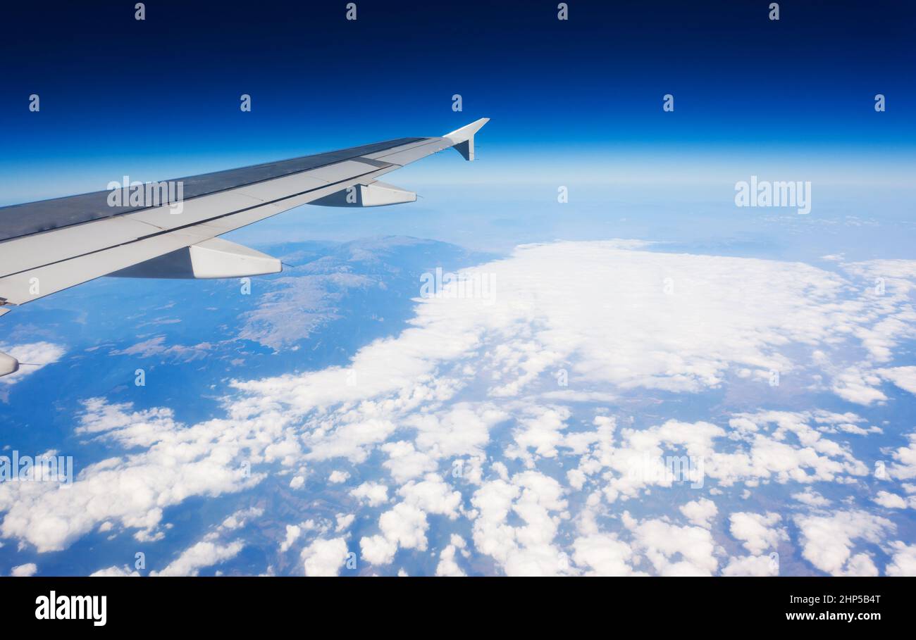 Ala di aeroplano che vola sopra le nuvole nel cielo Foto Stock